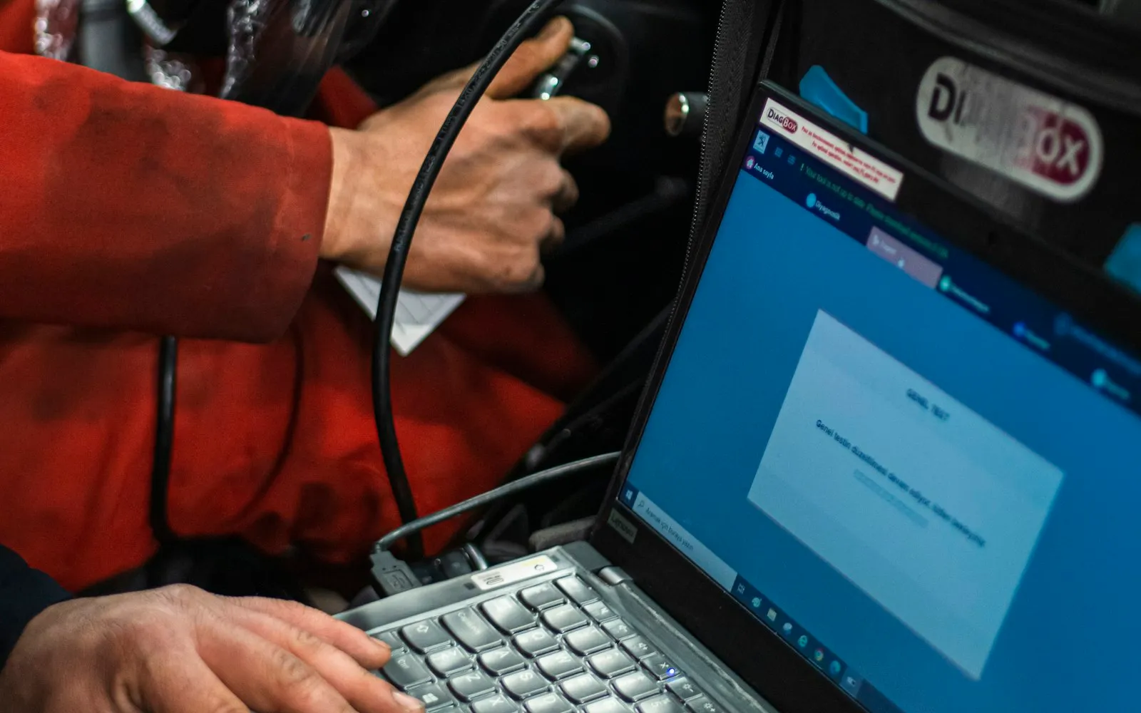 Mechaniker liest Fahrzeugdaten mit einem Diagnosegerät aus